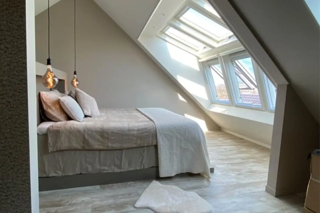 Prachtige slaapkamer in rustige natuurtinten met veel lichtinval van de dakserre.