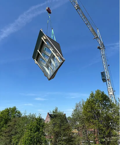 Een dakserre die wordt geplaatst met een hijskraan